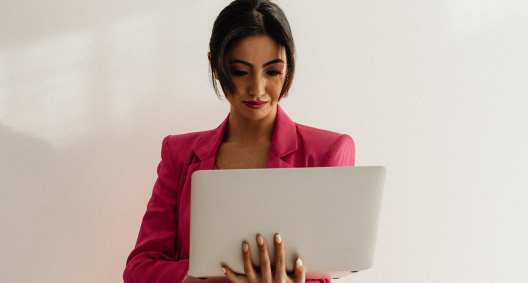 femme en costume rose avec un ordinateur